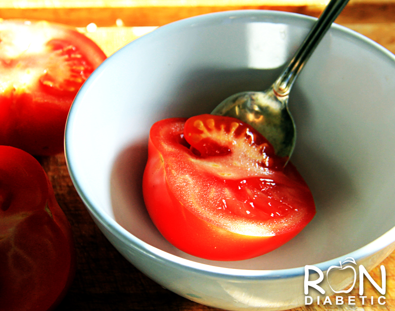 Разрезать помидор пополам и чайной ложкой удалить середину с семечками